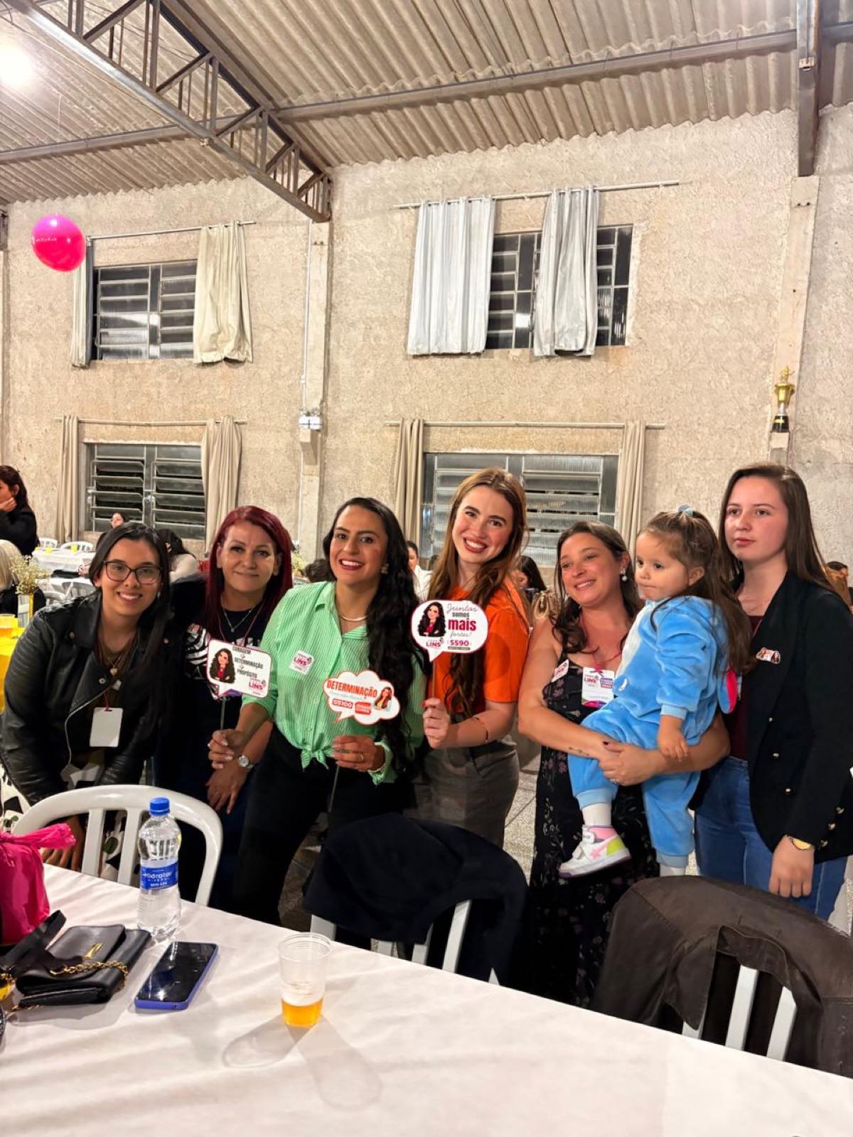 Cabo Lins cercada de apoiadoras, com uma criança no colo